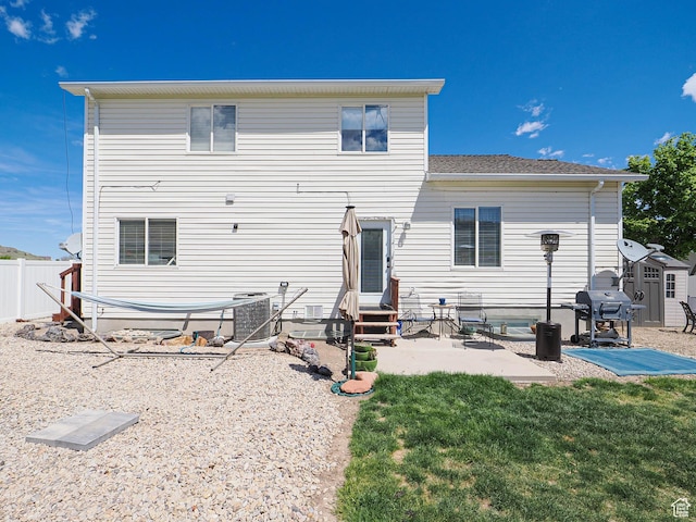 rear view of property featuring a patio area, entry steps, cooling unit, and a storage shed