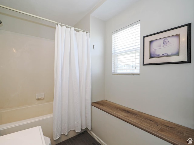 bathroom featuring shower / bath combination with curtain and toilet