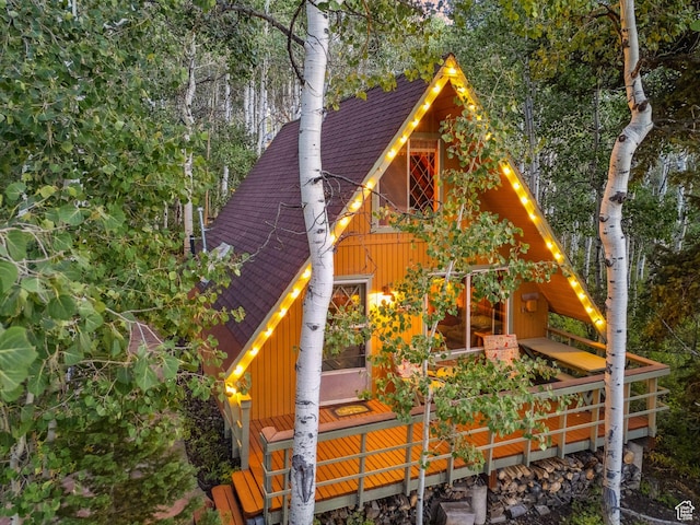view of side of home with roof with shingles and board and batten siding