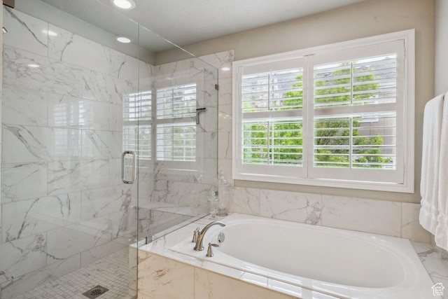 full bathroom with a bath, plenty of natural light, and a marble finish shower