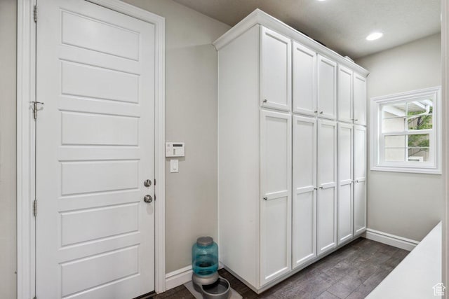 clothes washing area featuring baseboards, dark wood finished floors, and recessed lighting
