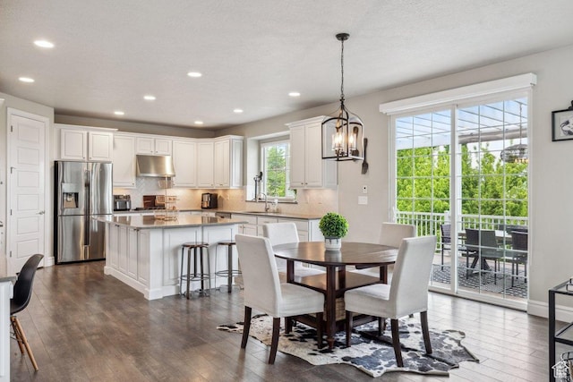 dining room with dark wood-type flooring, recessed lighting, and a chandelier
