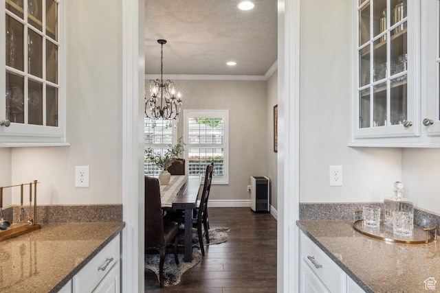 bar area with a textured ceiling, crown molding, dark wood finished floors, a chandelier, and recessed lighting