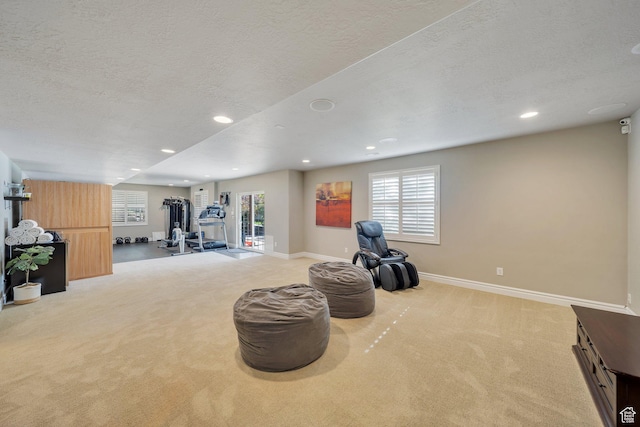 exercise room featuring carpet floors, healthy amount of natural light, a textured ceiling, recessed lighting, and baseboards