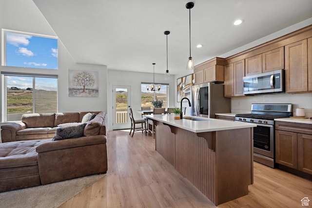 2005 N 4260 W, Lehi, UT 84043 - kitchen featuring stainless steel appliances, open floor plan, light countertops, a breakfast bar area, and light wood-type flooring