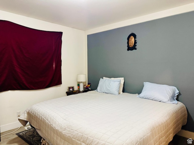 bedroom featuring baseboards and wood finished floors