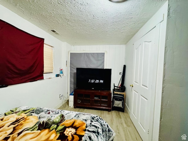 bedroom with wood finished floors and a textured ceiling