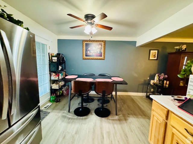 kitchen with freestanding refrigerator, light wood finished floors, a ceiling fan, and baseboards