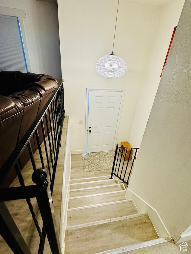 stairs with wood finished floors and baseboards