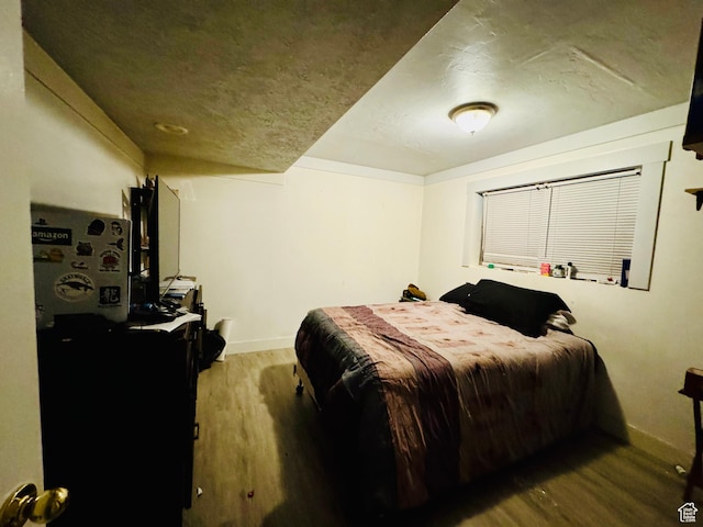 bedroom with wood finished floors and baseboards