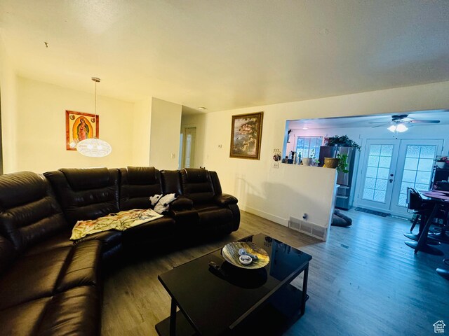 living room with wood finished floors, a ceiling fan, and baseboards