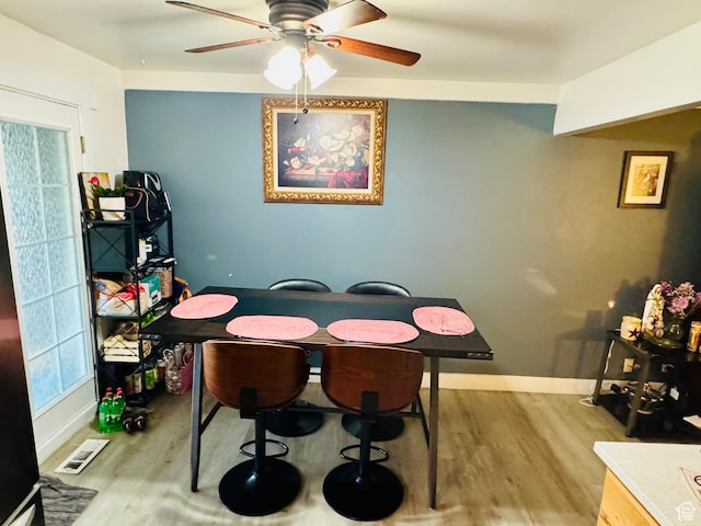 dining area with wood finished floors, ceiling fan, and baseboards