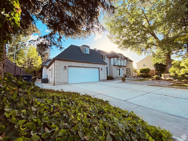 view of front of home featuring brick siding, driveway, an attached garage, fence, and a shingled roof