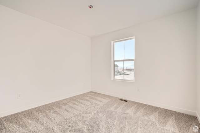 carpeted empty room with baseboards