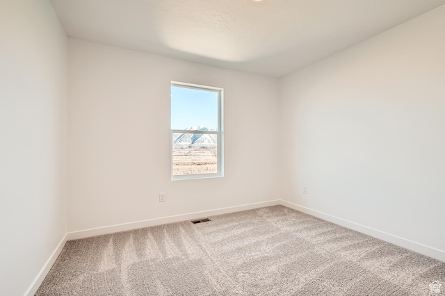 unfurnished room with carpet and baseboards