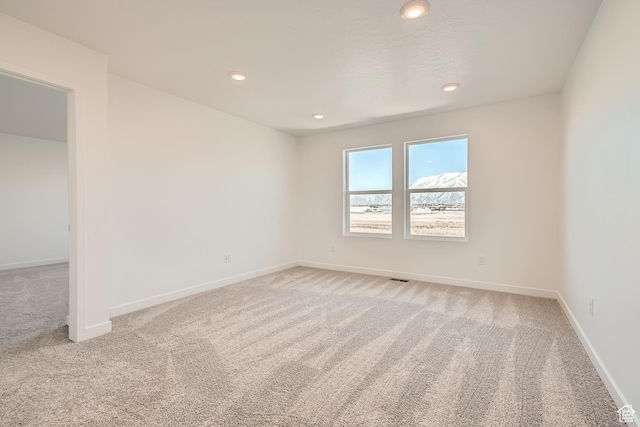 unfurnished room with light colored carpet, baseboards, and recessed lighting