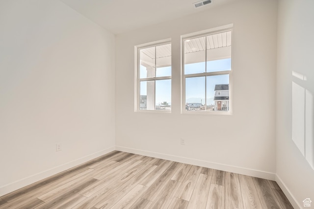 unfurnished room featuring light wood finished floors and baseboards