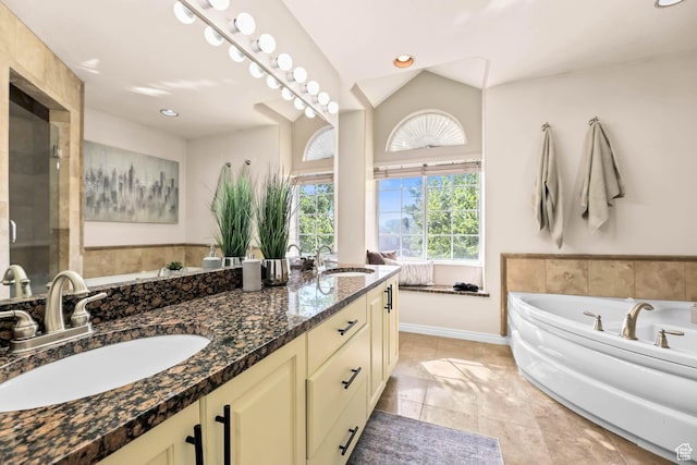 8017 S Showcase Ln, Sandy, UT 84094 - bathroom featuring double vanity, a garden tub, baseboards, and recessed lighting