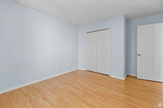 8017 S Showcase Ln, Sandy, UT 84094 - unfurnished bedroom featuring baseboards, light wood-style floors, and a closet