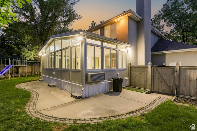 8017 S Showcase Ln, Sandy, UT 84094 - rear view of house with a sunroom, a gate, a playground, a patio, and a chimney