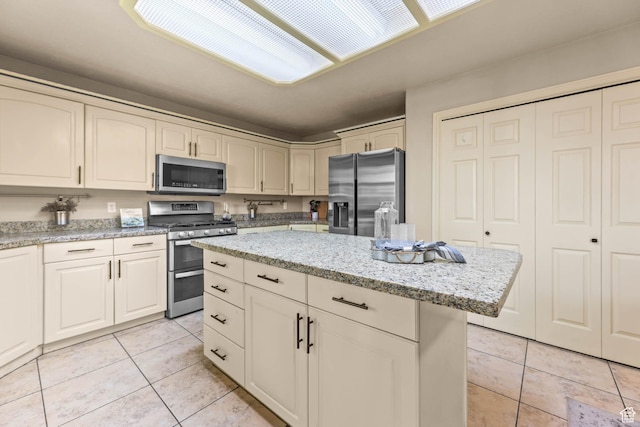 8017 S Showcase Ln, Sandy, UT 84094 - kitchen featuring stainless steel appliances, light tile patterned floors, a center island, and light stone countertops