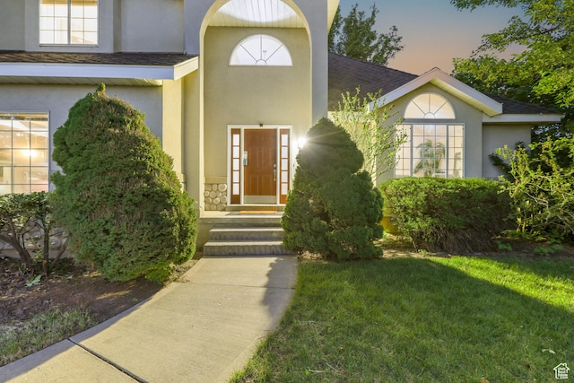 8017 S Showcase Ln, Sandy, UT 84094 - exterior entry at dusk featuring stucco siding and a lawn