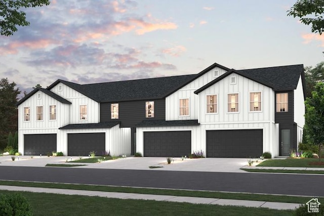 modern farmhouse featuring an attached garage, board and batten siding, concrete driveway, and roof with shingles