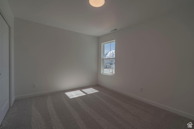 spare room featuring carpet floors and baseboards