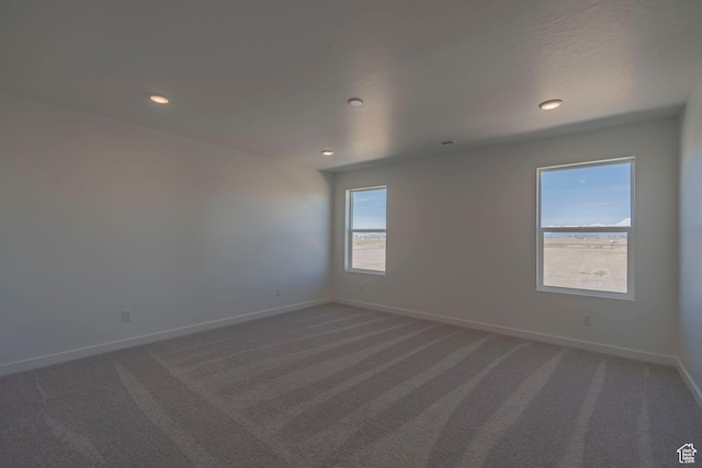 spare room featuring carpet flooring, baseboards, and recessed lighting