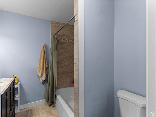 bathroom featuring vanity, toilet, shower / bath combo, and baseboards