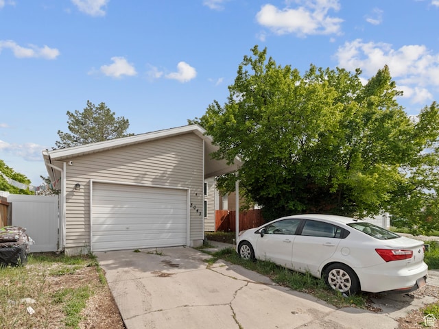 view of home's exterior featuring fence and driveway