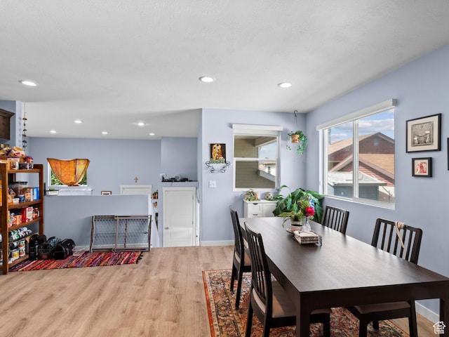 dining space featuring light wood-style flooring, recessed lighting, and baseboards
