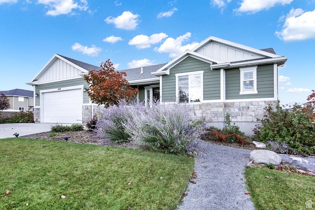 view of front facade featuring board and batten siding, stone siding, a front yard, and driveway