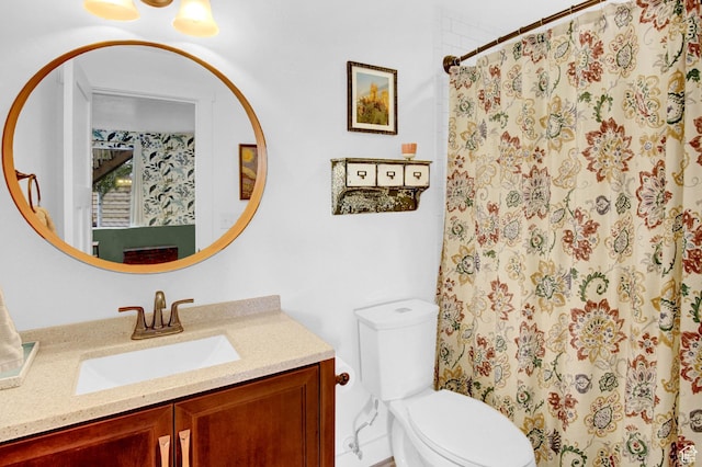 bathroom featuring toilet, vanity, and a shower with curtain