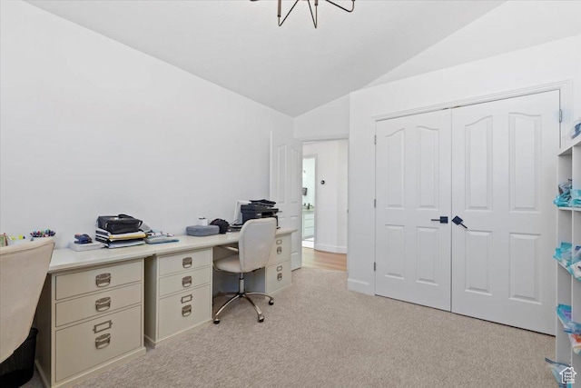 home office with lofted ceiling and light carpet