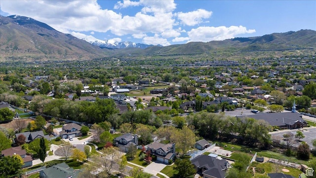 aerial view of property and surrounding area featuring a mountainous background and nearby suburban area
