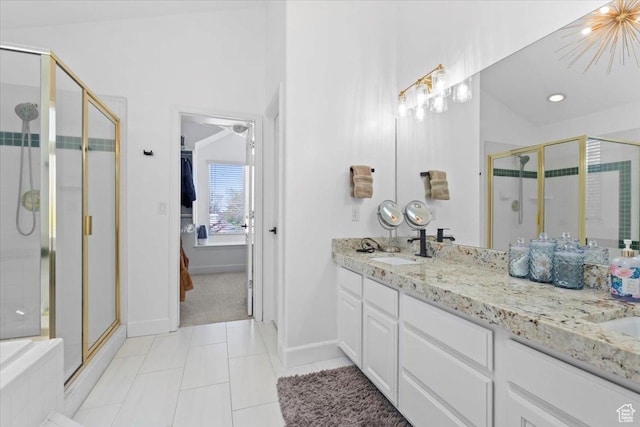 full bathroom with a stall shower, double vanity, tile patterned floors, and baseboards