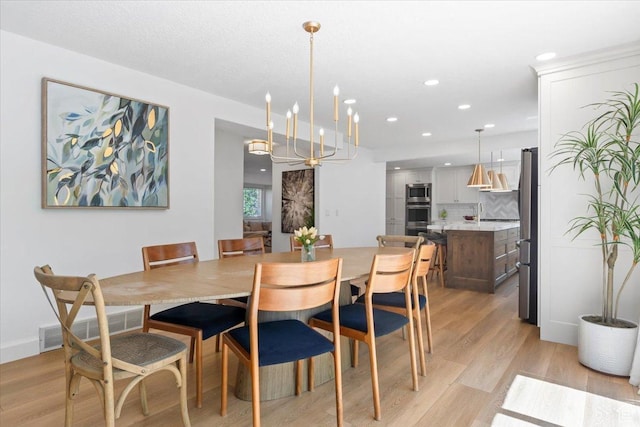 dining room featuring light wood finished floors, recessed lighting, and a chandelier