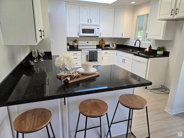 1731 S 145 E, Orem, UT 84058 - kitchen featuring white appliances, a sink, a peninsula, a kitchen breakfast bar, and white cabinets