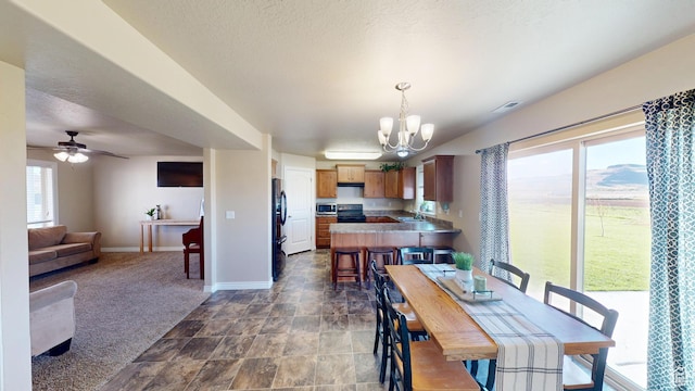 90 W Cedar Ln, Franklin, ID 83237 - dining area featuring a chandelier, baseboards, stone finish floors, ceiling fan, and dark colored carpet