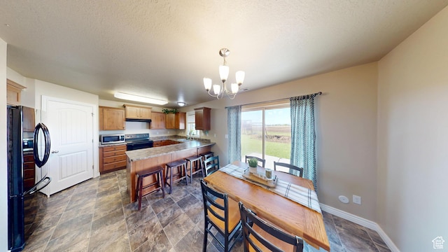 90 W Cedar Ln, Franklin, ID 83237 - dining space featuring a chandelier, stone finish floors, a textured ceiling, and baseboards