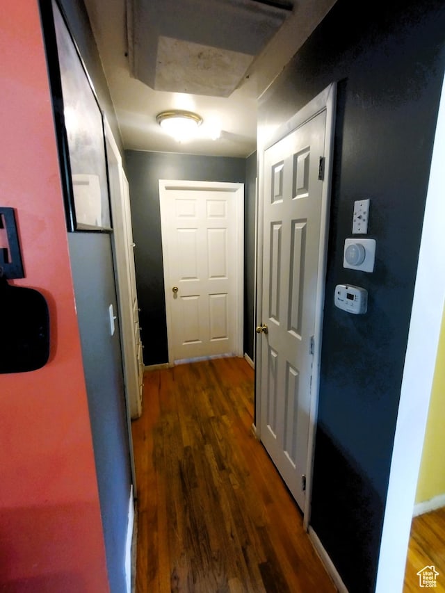 corridor featuring wood finished floors and baseboards