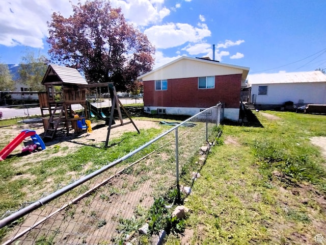 view of side of home featuring a playground and brick siding