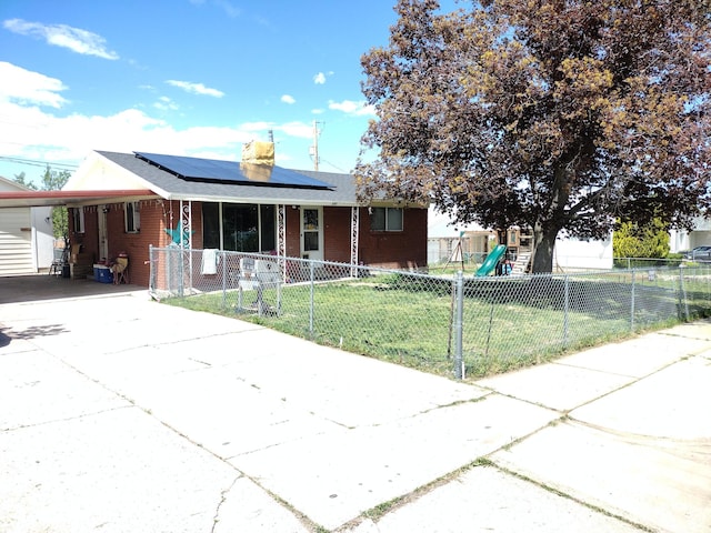 single story home with driveway, an attached carport, covered porch, brick siding, and roof mounted solar panels
