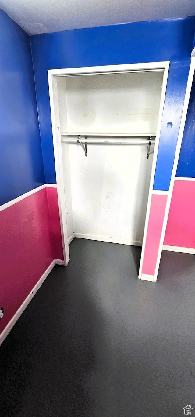 unfurnished bedroom with baseboards and a closet