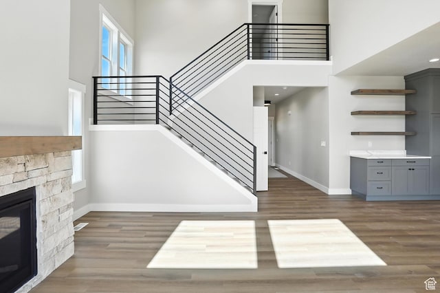 1734 N 4100 W, Plain City, UT 84404 - unfurnished living room with stairway, a high ceiling, wood finished floors, and a fireplace