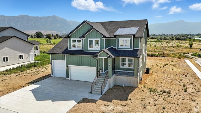 1734 N 4100 W, Plain City, UT 84404 - view of front of home featuring board and batten siding, roof with shingles, concrete driveway, and a mountain view
