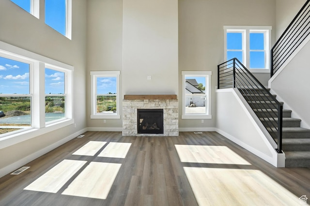 1734 N 4100 W, Plain City, UT 84404 - unfurnished living room featuring a towering ceiling, wood finished floors, stairs, and a fireplace