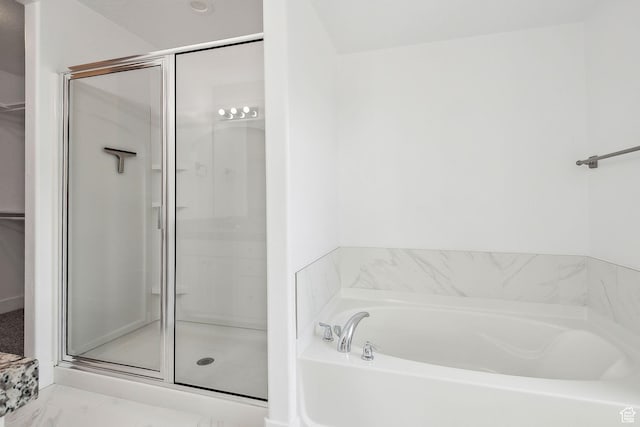 full bath featuring a shower stall, a bath, marble look tiles, and a walk in closet
