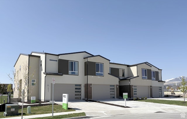 6041 W Lower Ln # 6-234, West Jordan, UT 84081 - view of front of property with an attached garage, stucco siding, driveway, and a mountain view